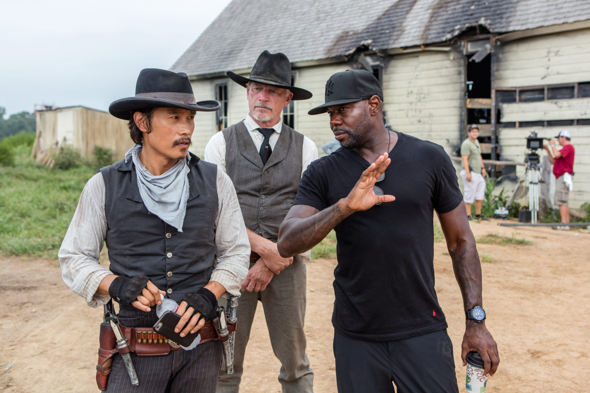 Byung-hun Lee (left) and director Antoine Fuqua (right) on the set of Metro-Goldwyn-Mayer Pictures and Columbia Pictures' THE MAGNIFICENT SEVEN.