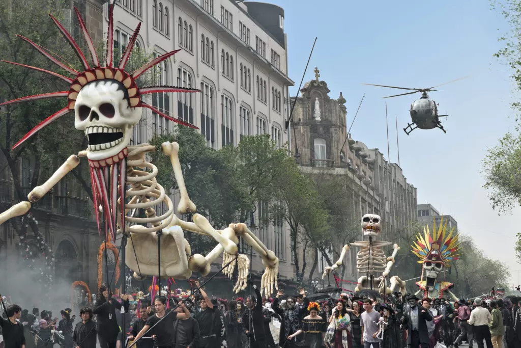 Bond chases Sciarra through the Day of the Dead parade in Mexico City. Scairra’s helicopter swoops in to collect him in Metro-Goldwyn-Mayer Pictures/Columbia Pictures/EON Productions’ action adventure SPECTRE.